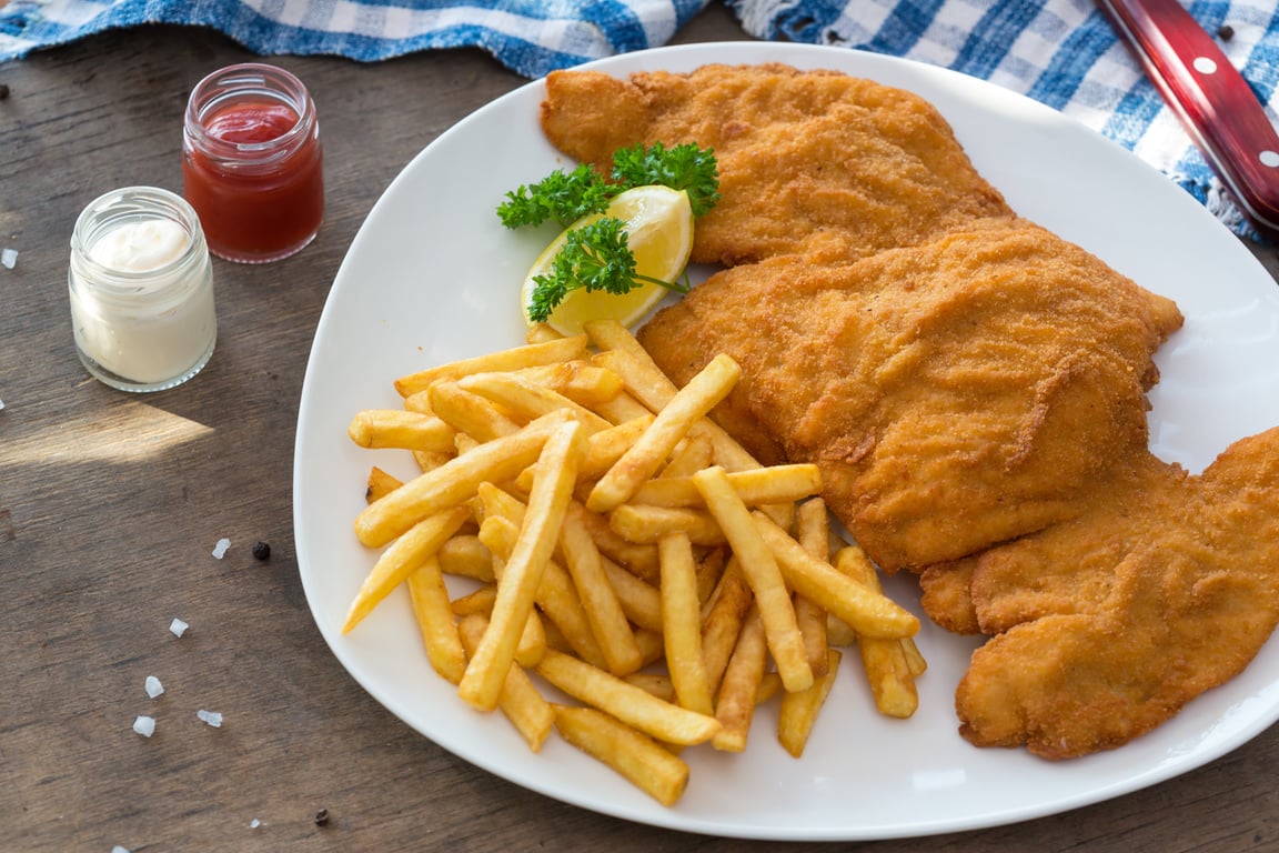 Chicken schnitzel. Breaded chicken schnitzel fries potatoes and sauces